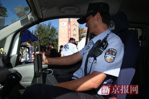 人大附中门口,海淀分局民警,手持防暴枪坐在警车内.