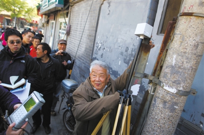 大茶叶胡同,中国地震局地震预测所研究员沈梦培举着仪器贴近一根电缆