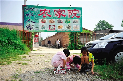 几个孩子在沁水营某处农家院门外玩耍.